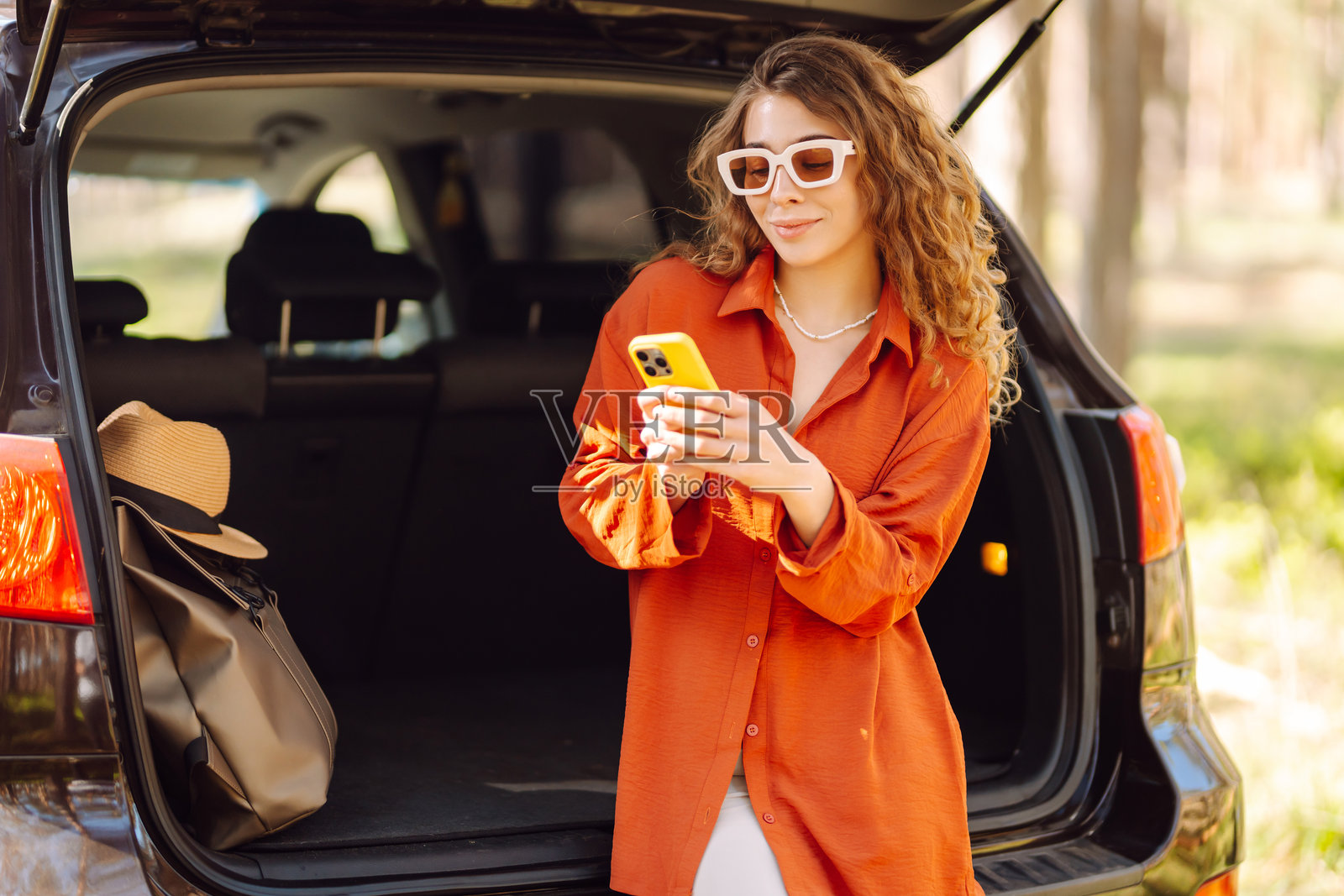快乐的女性旅行者从车窗外探出身子,感受自由。照片摄影图片