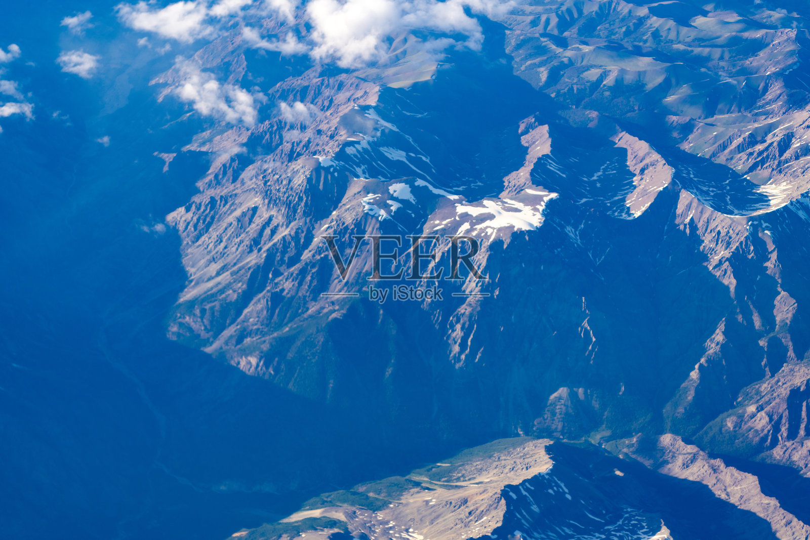 山地风景的鸟瞰图。云层中的鸟瞰视角。从飞机上俯瞰的风景。云雾中的山顶。云雾环绕的山地风景。云与山峰的鸟瞰图。照片摄影图片