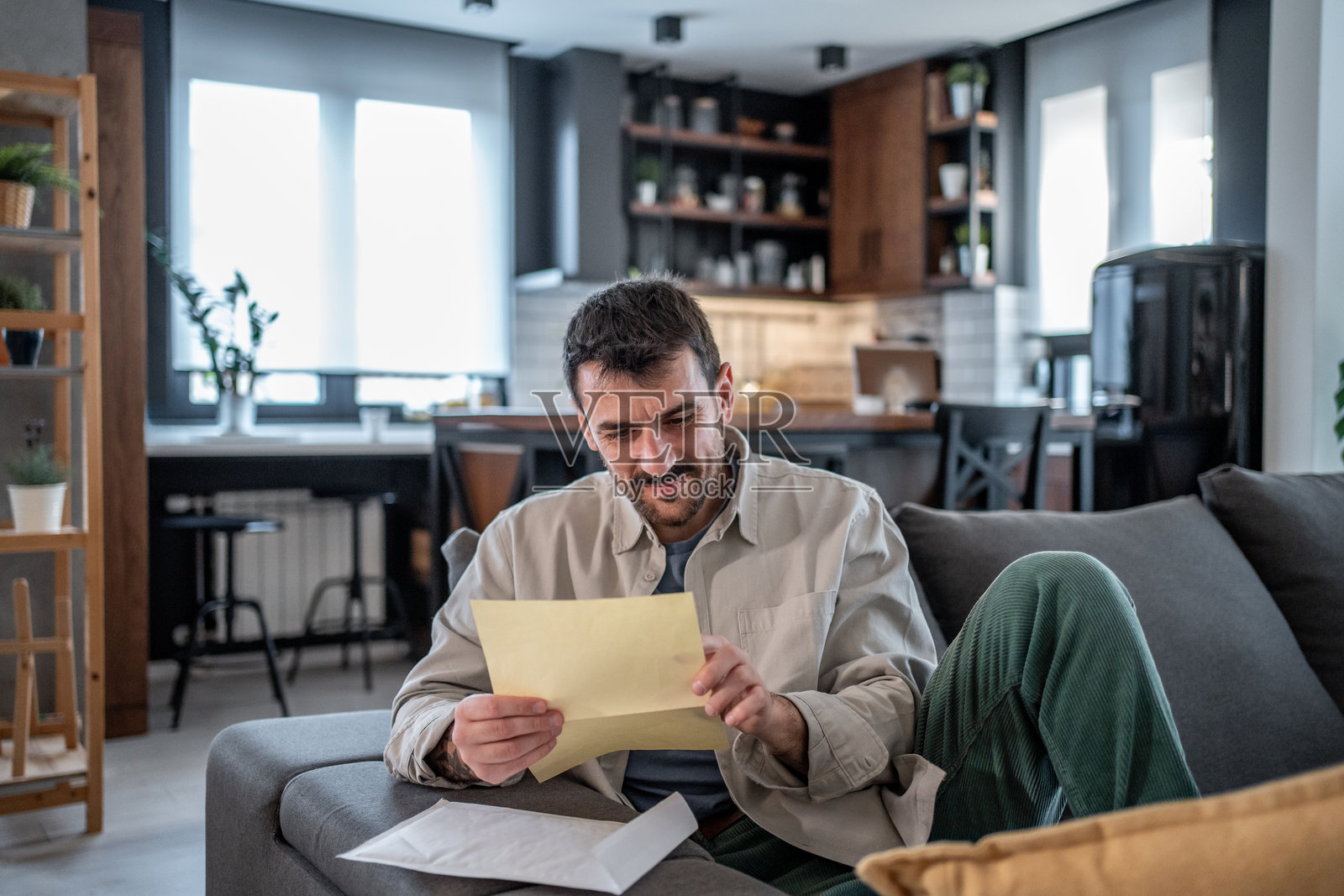微笑的男人在家中阅读信件中的好消息照片摄影图片