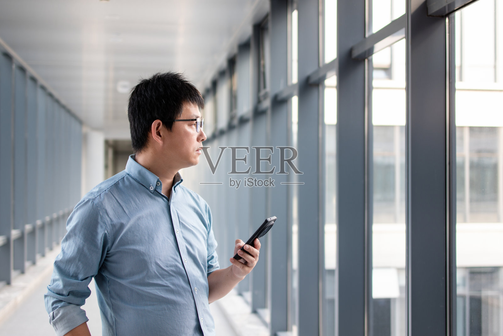 亚洲商人在办公室使用智能手机照片摄影图片