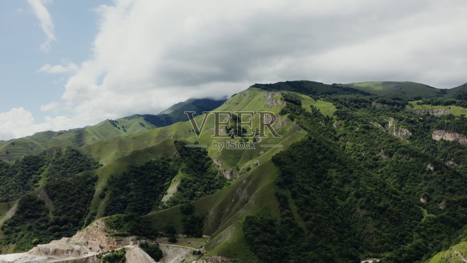 美丽的绿色山脉,岩石陡峭,覆盖着茂密的森林照片摄影图片
