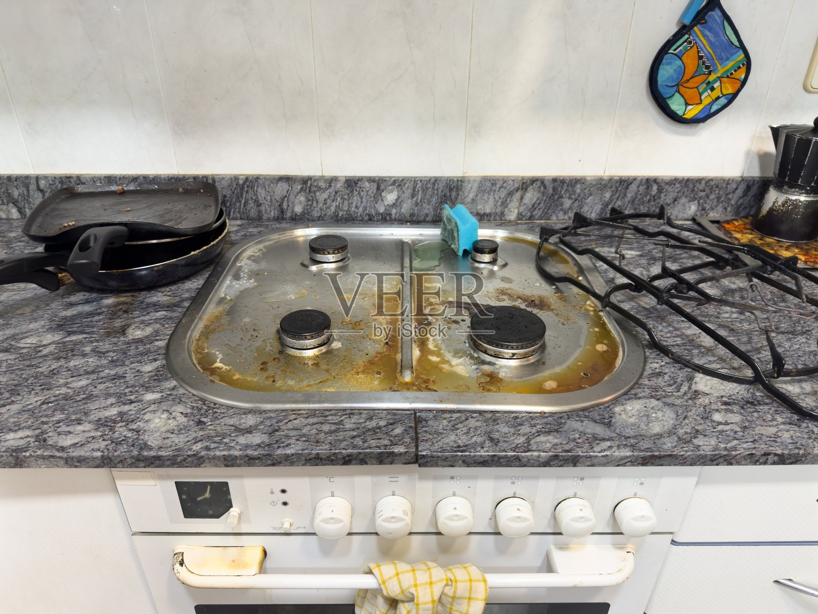 脏污的煤气灶上有烧焦的食物和油渍,需要清洁。照片摄影图片