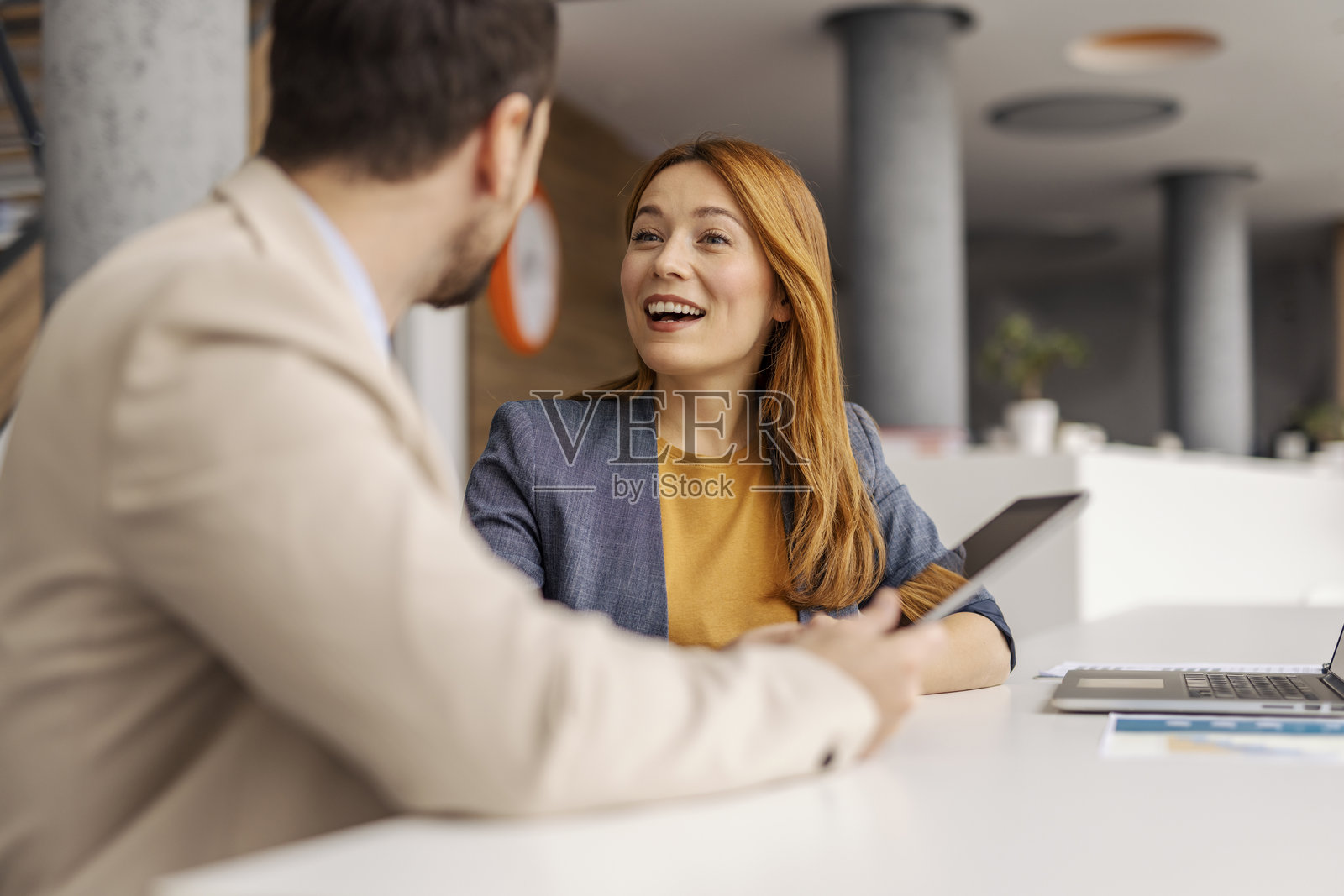 微笑的女商人在会议室与同事讨论商业战略。照片摄影图片