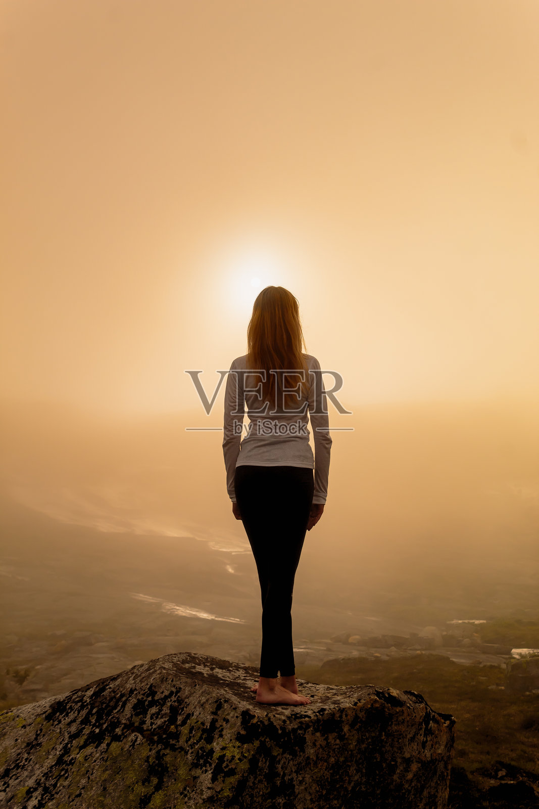女人在晨雾中面对升起的太阳照片摄影图片