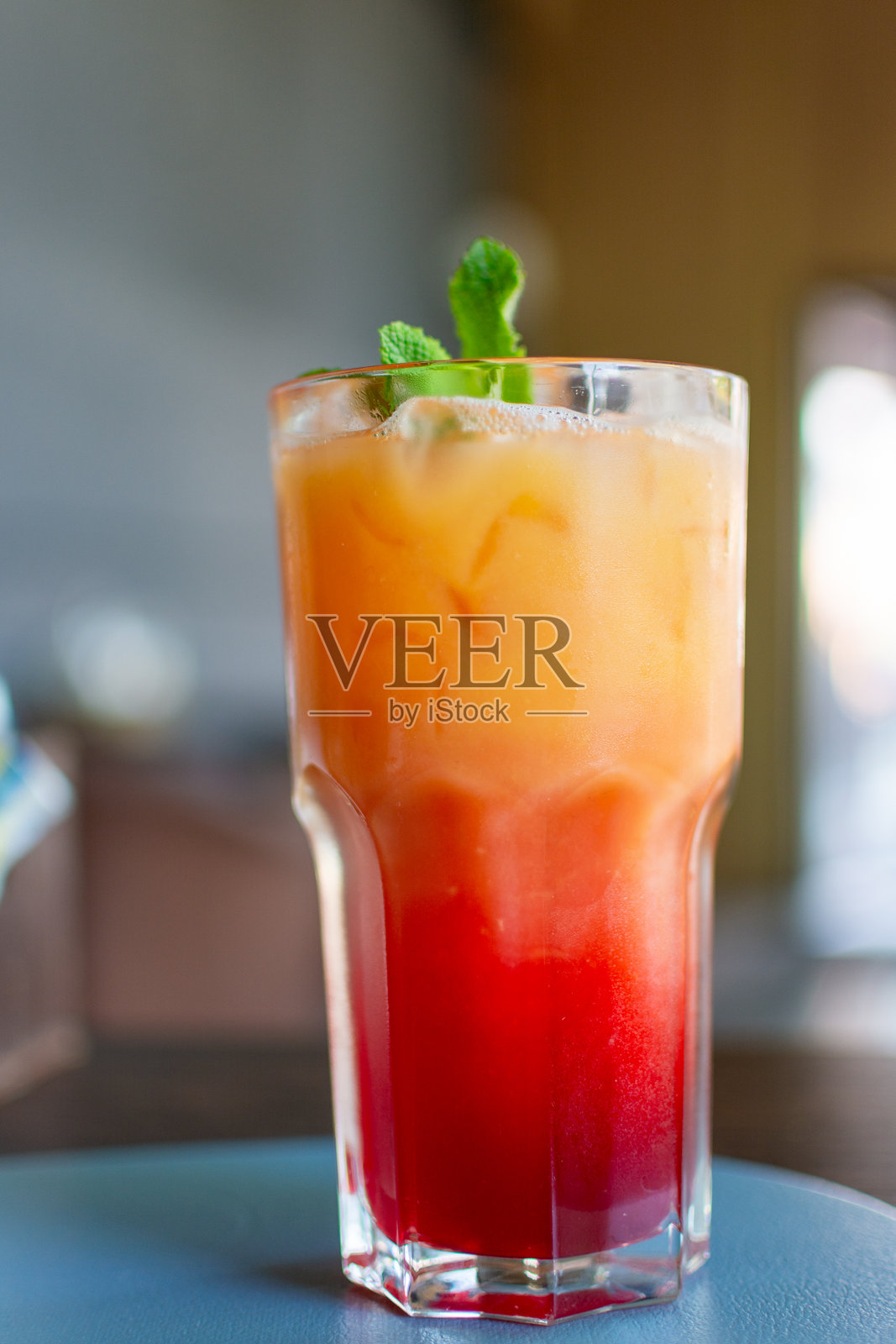 这是一款清爽的红色鸡尾酒,配有冰块和薄荷。是一款基于果汁的夏季饮品。照片摄影图片