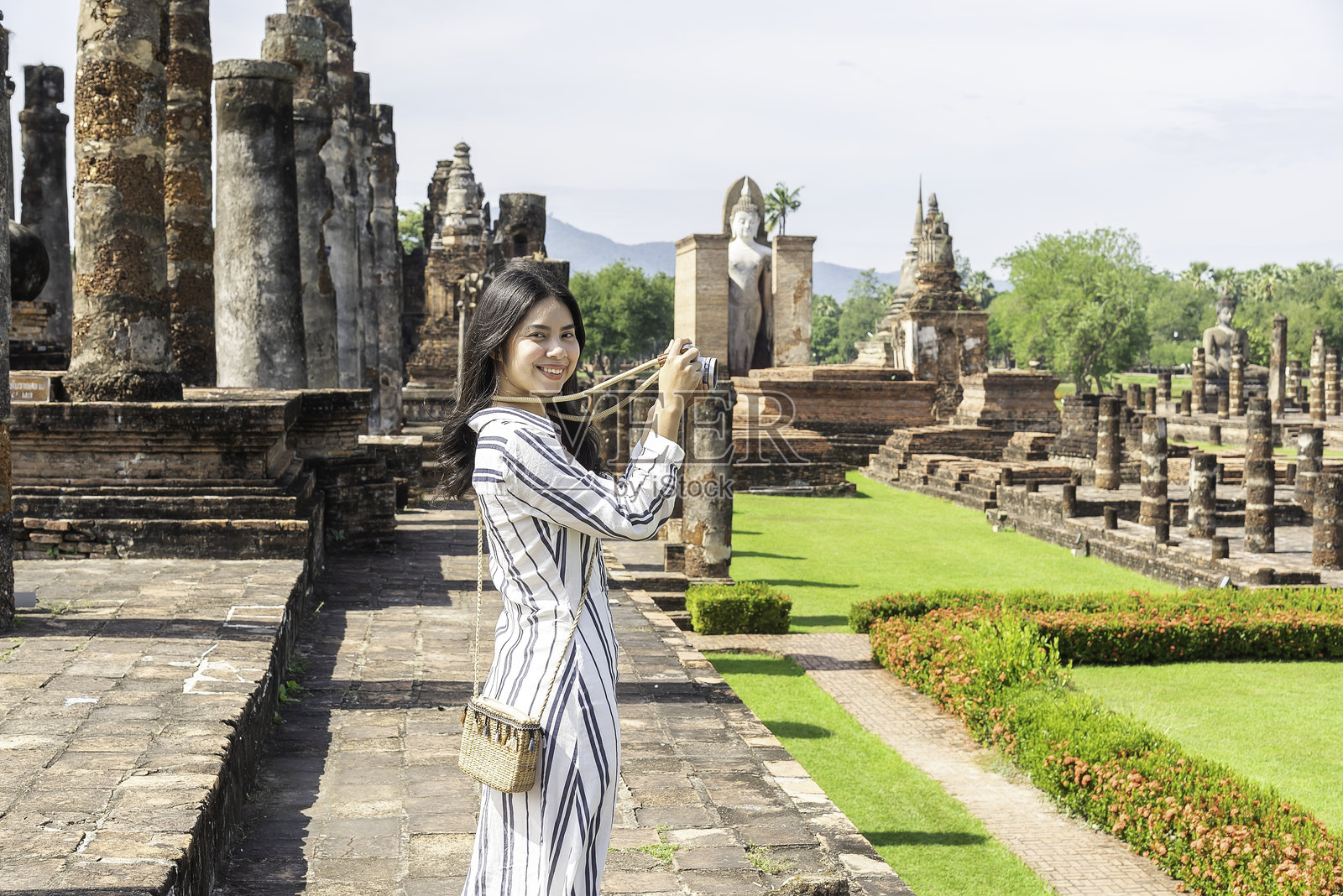 旅行者和女游客享受在泰国历史公园散步,兴奋地探索这个美丽的观光胜地。照片摄影图片