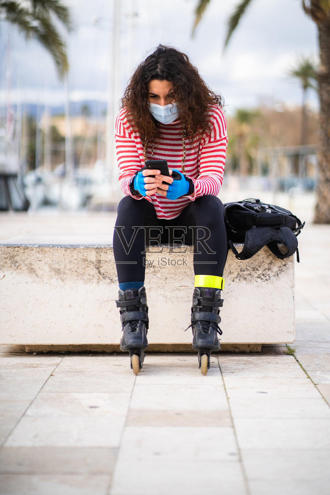 手持智能手机的滑冰女子照片摄影图片