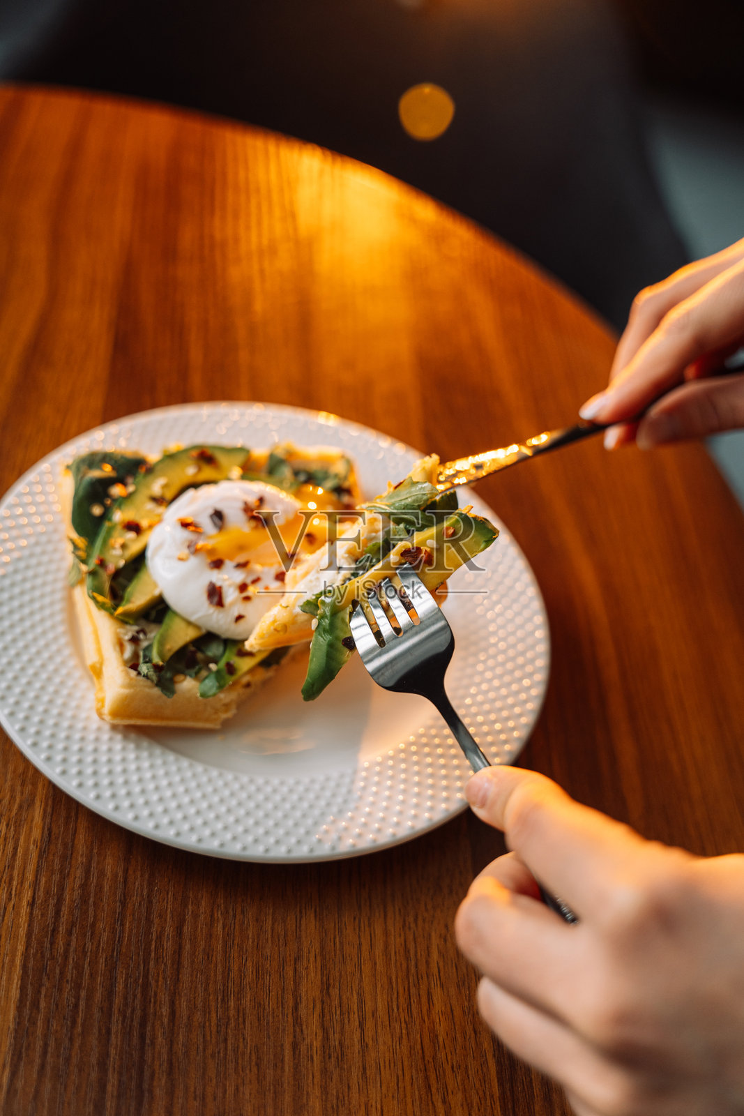 木桌上盘子里的华夫饼配水煮蛋和鳄梨照片摄影图片