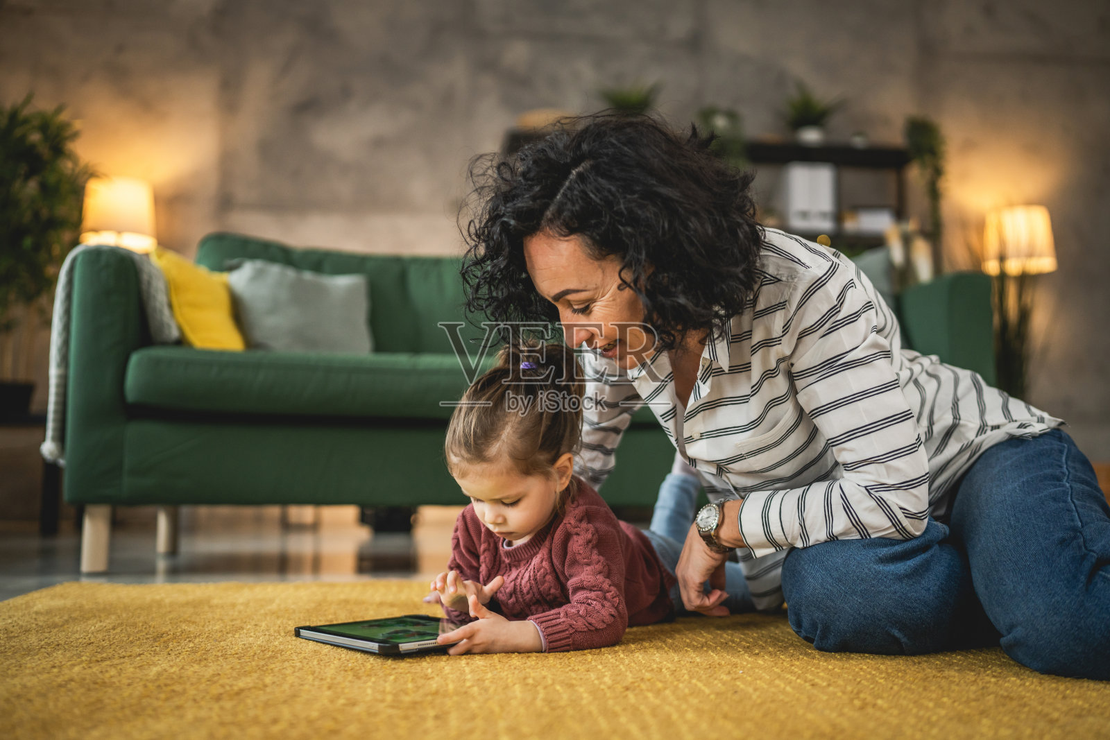 母亲和女儿在家里使用平板电脑观看在线视频照片摄影图片