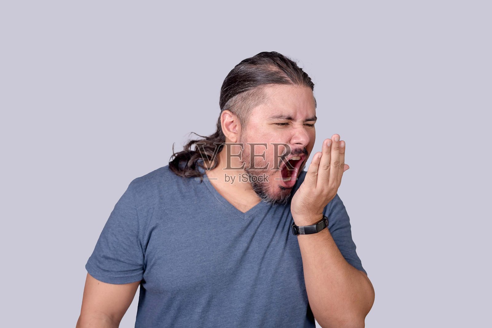 一名男子通过对着手掌呼气来检查口臭,查看是否有口臭或其他口腔问题的迹象。照片摄影图片