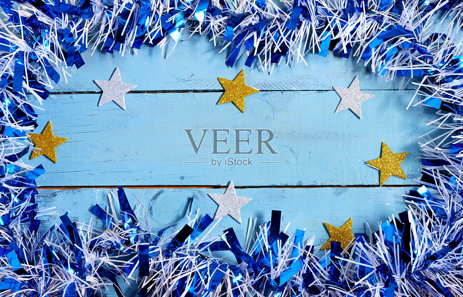 节日蓝色木质背景,星星和闪亮的花环照片摄影图片