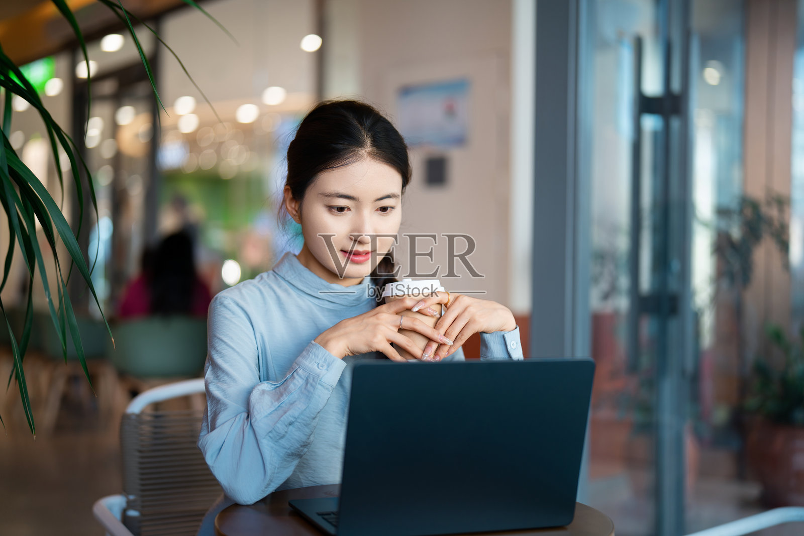 亚洲年轻女性在咖啡店使用笔记本电脑照片摄影图片