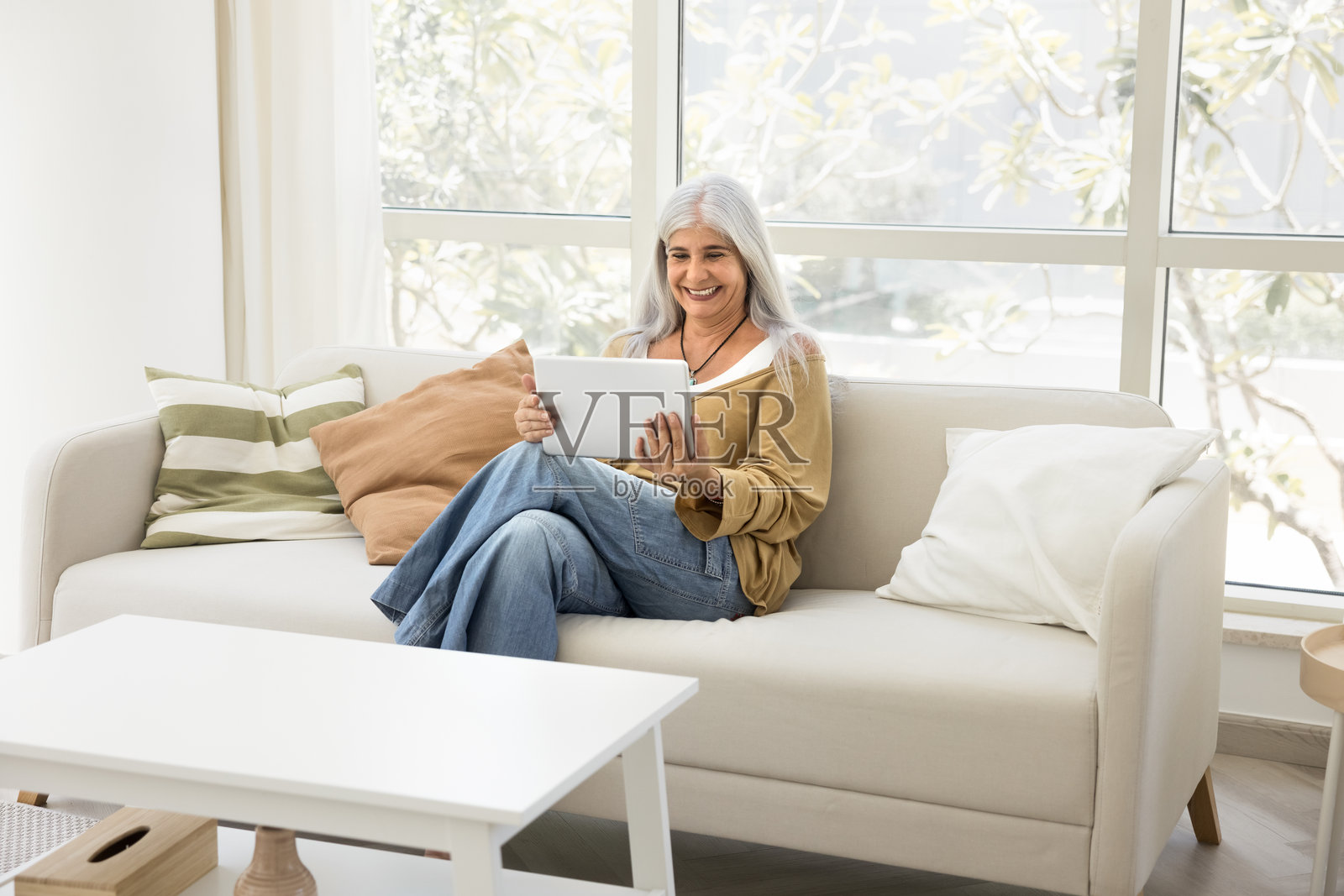 快乐的退休老年女性使用平板电脑进行在线交流照片摄影图片