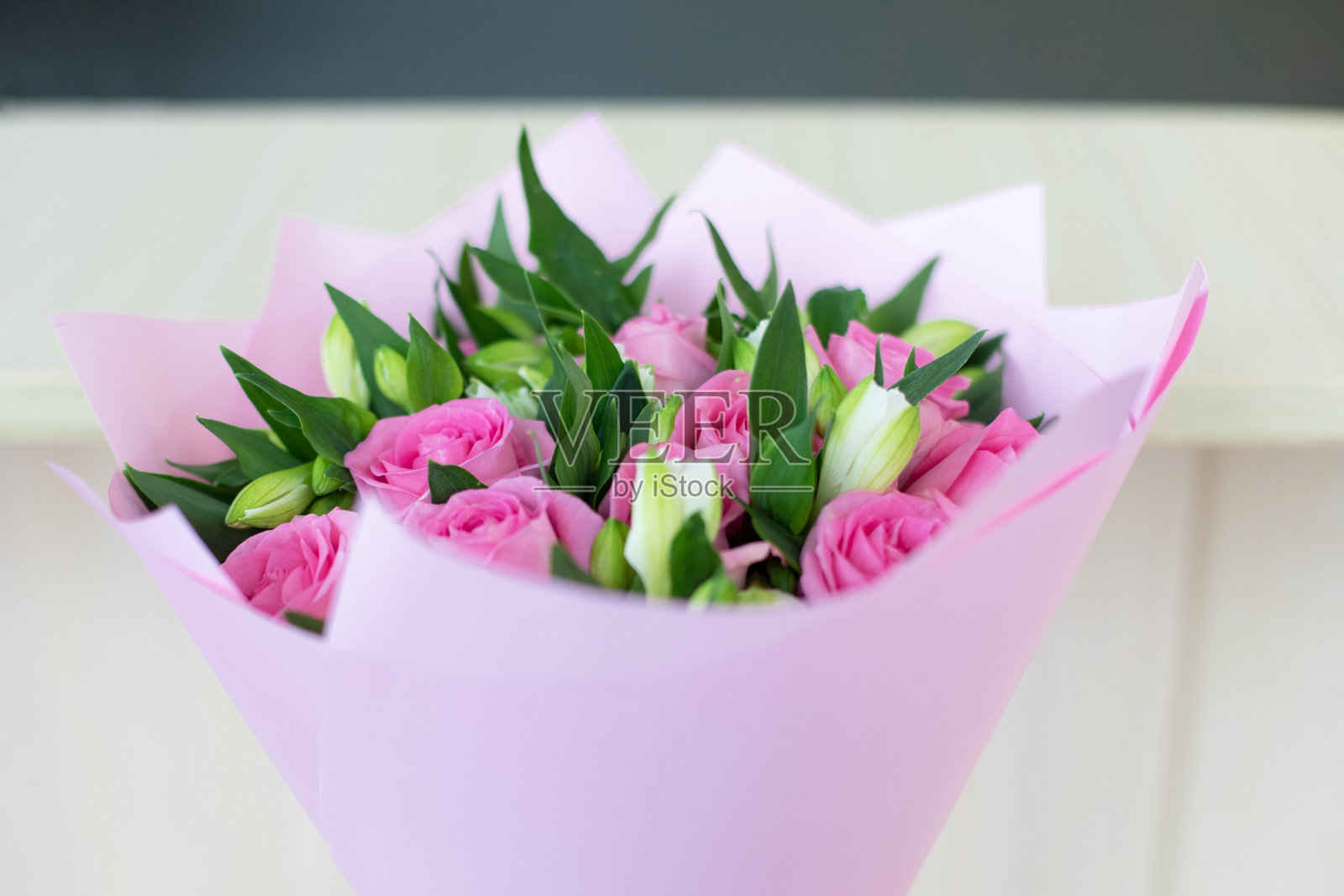 桌子上的粉色玫瑰花束照片摄影图片