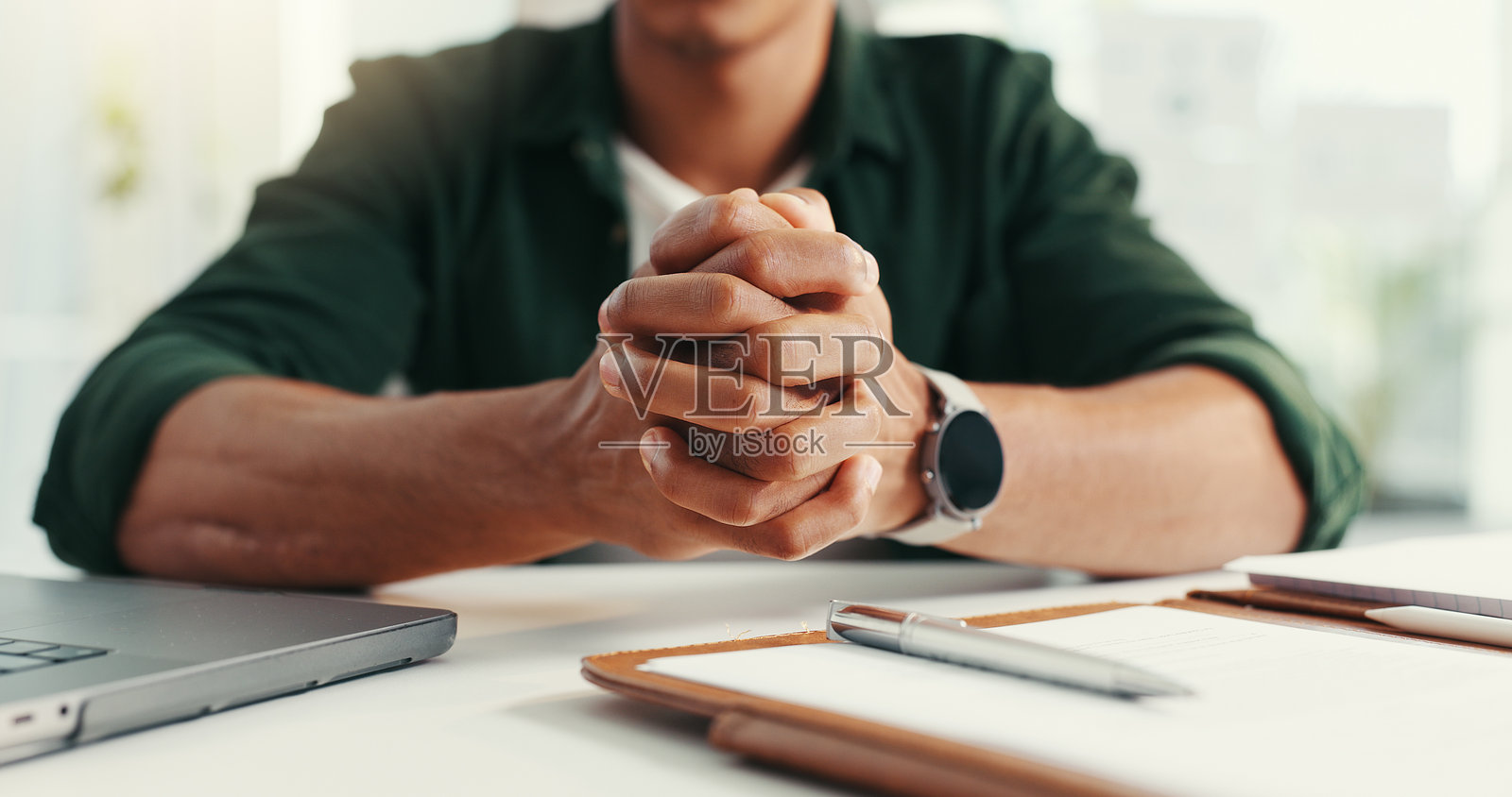 办公桌特写,手部在办公室使用笔记本电脑、文件和笔记进行创意规划。专业的工作场景,男性正在处理公司计划、日程安排和项目管理的文书工作。照片摄影图片