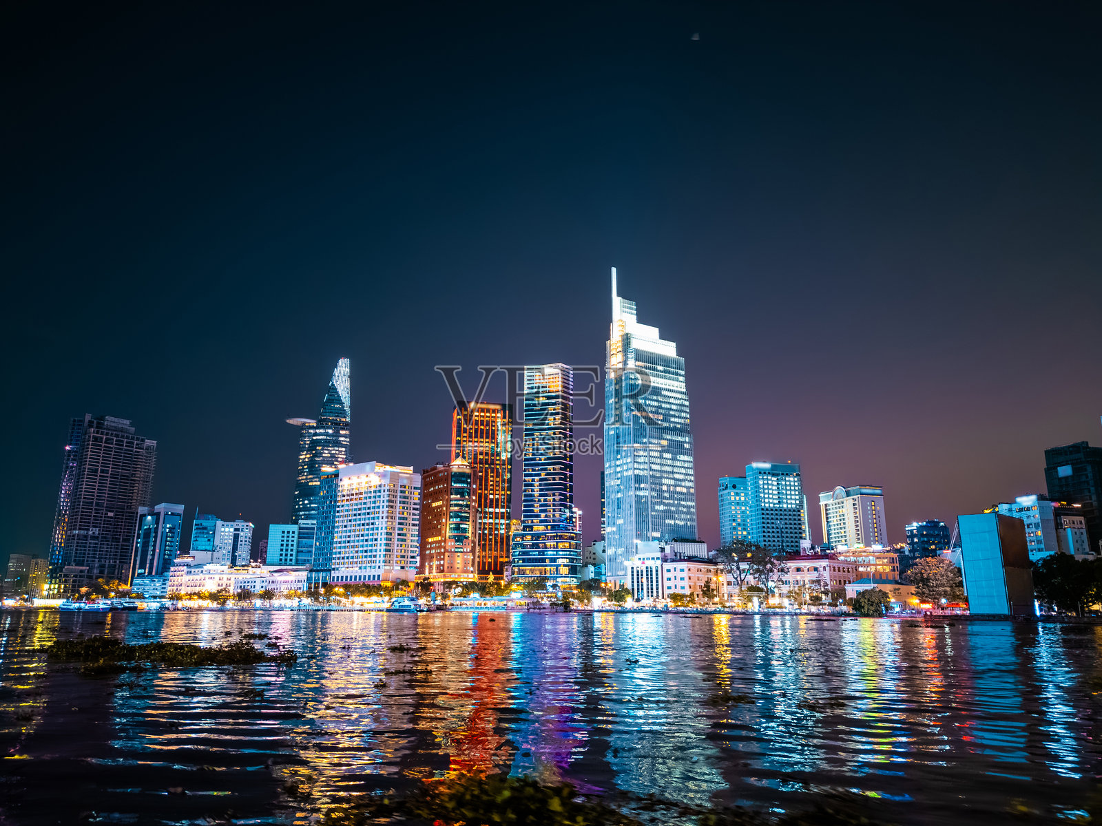 胡志明市夜景,灯火辉煌的天际线和西贡河,金融区霓虹街灯与高耸的摩天大楼,越南航拍视角照片摄影图片