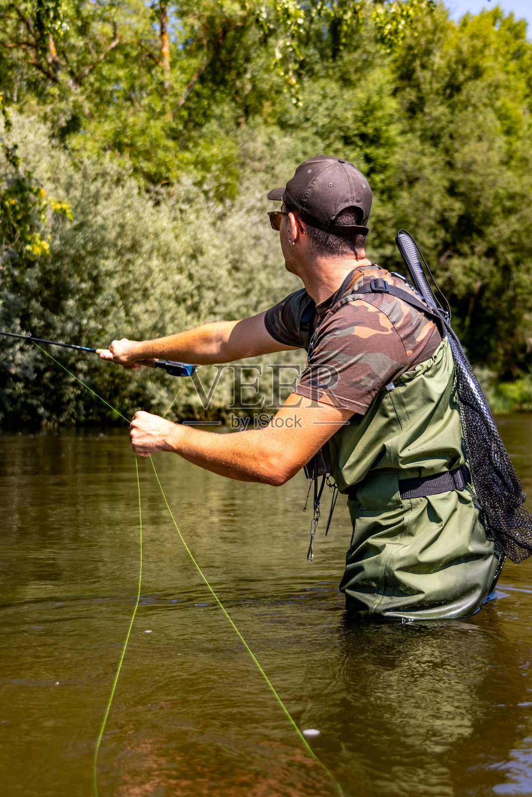 渔民在阳光明媚的日子里向河里抛线照片摄影图片