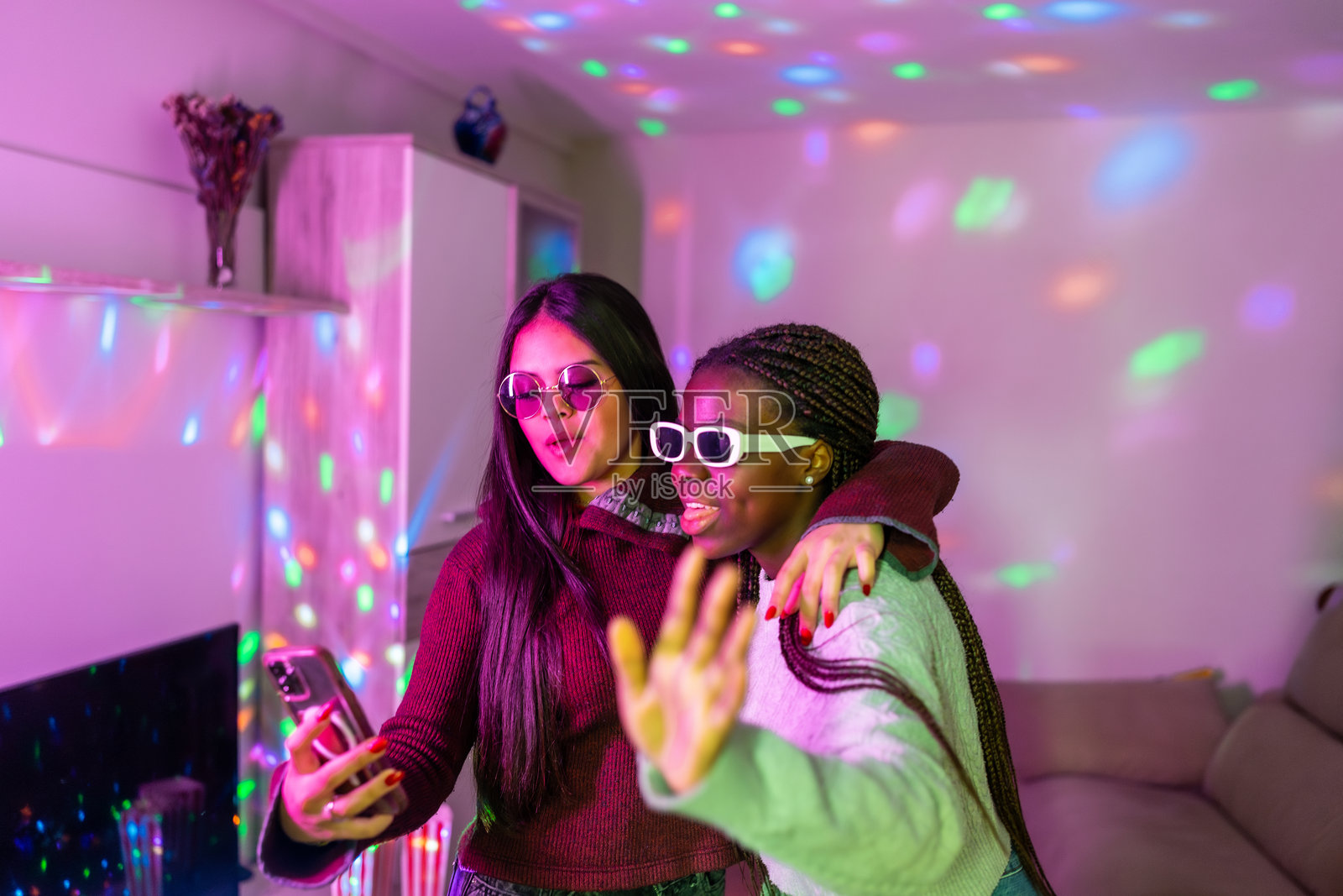 两个少女在家里用迪斯科灯拍自拍照照片摄影图片