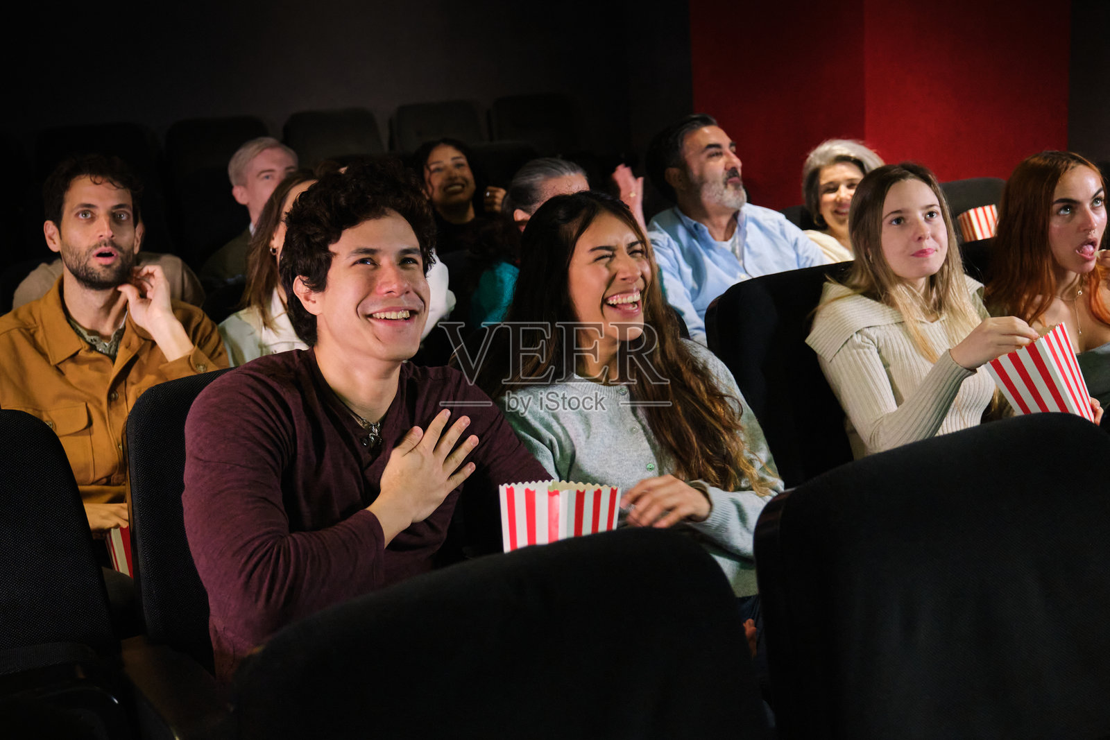 一群朋友在电影院观看喜剧,欢笑并享受乐趣照片摄影图片