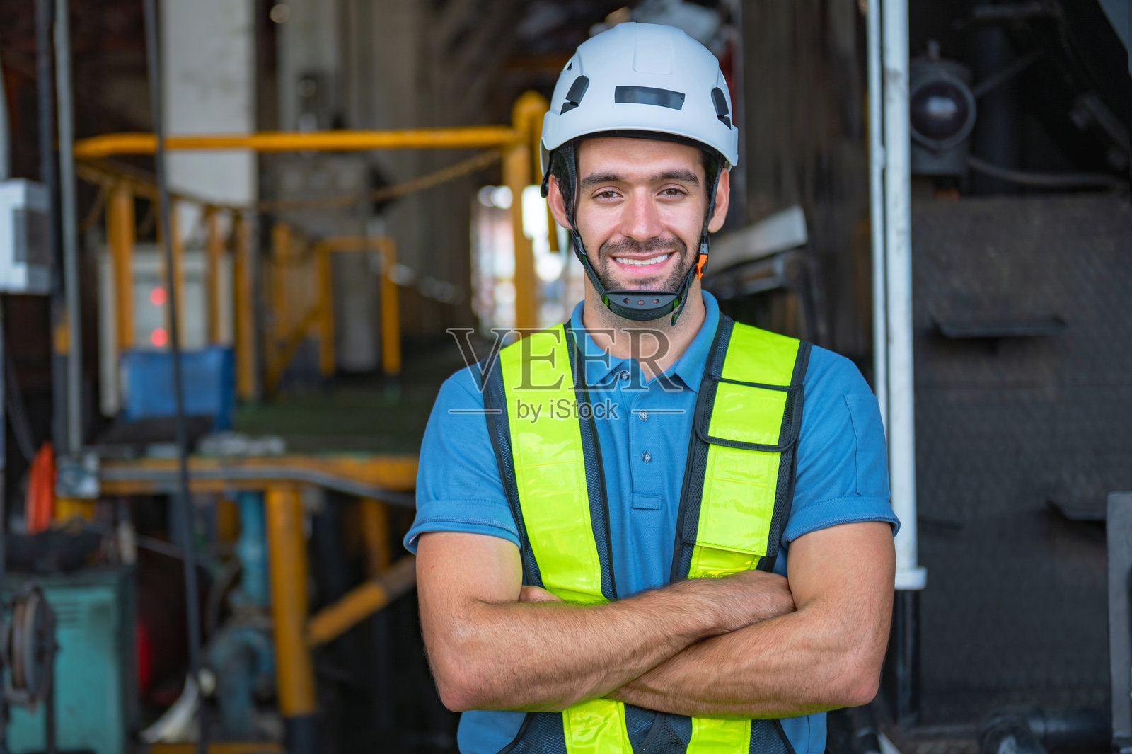 穿着黄色背心和头盔的男子在微笑照片摄影图片