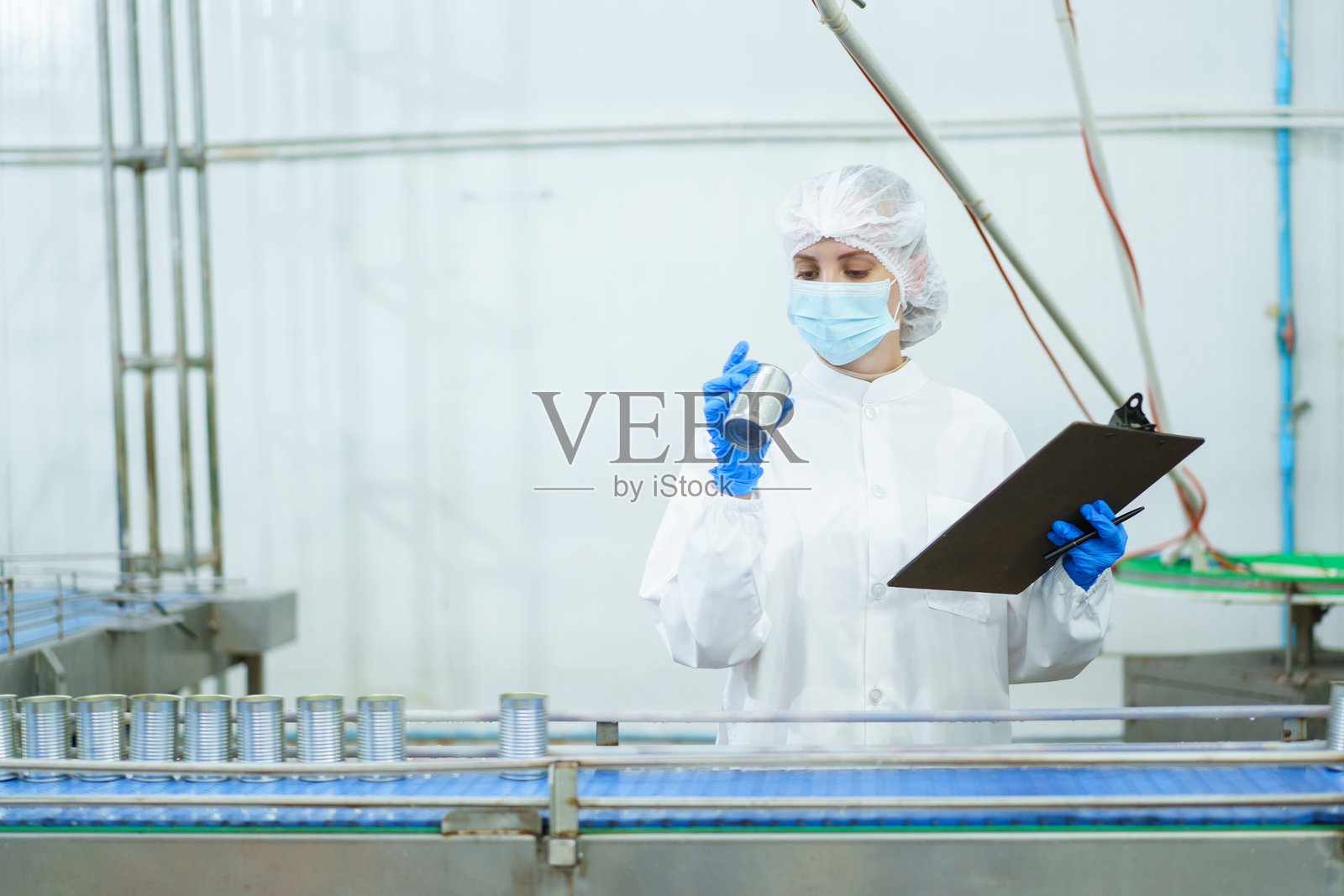 质量控制员正在随机检查罐头鱼生产设施中的原材料。照片摄影图片