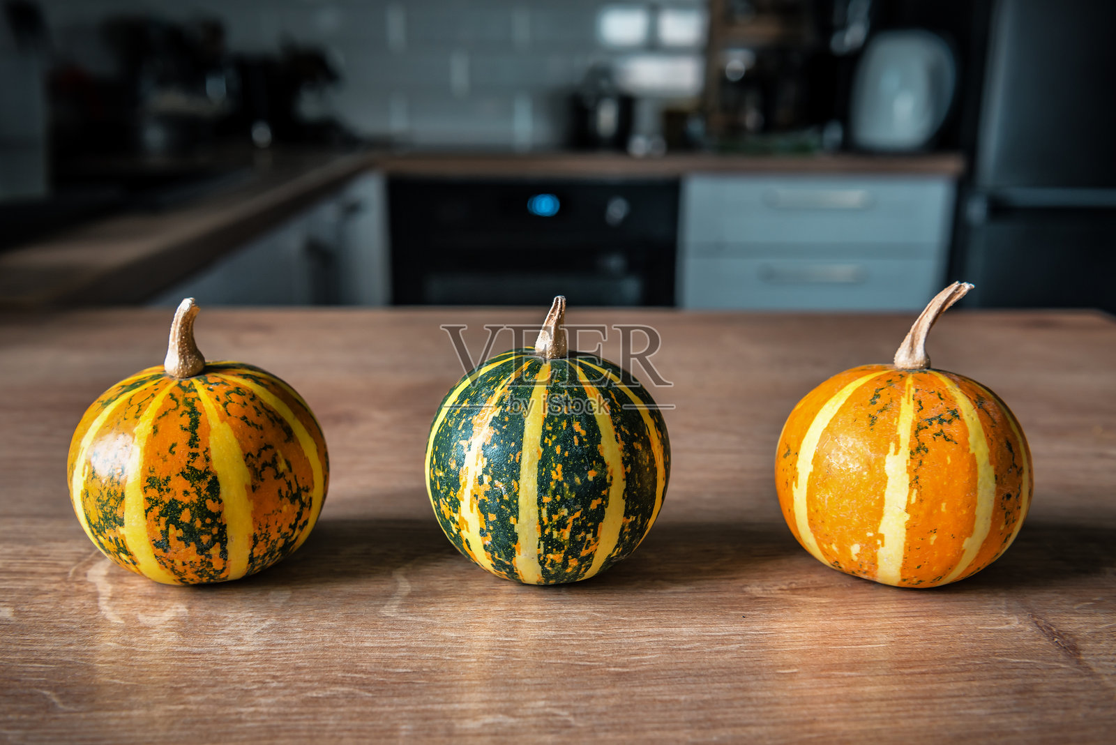 厨房桌子上的三个小南瓜照片摄影图片