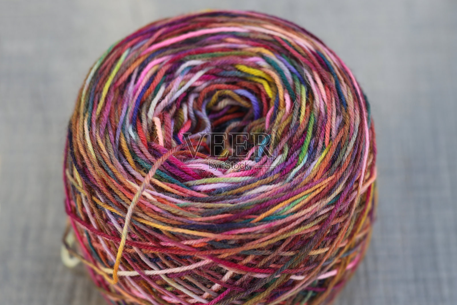 特写镜头展示了一团色彩鲜艳的手染袜子毛线,适合编织袜子和其他手工艺项目。照片摄影图片