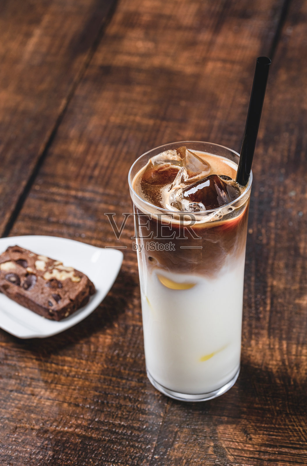 高杯装满冰块,木桌上放着混合了奶油的冰咖啡照片摄影图片