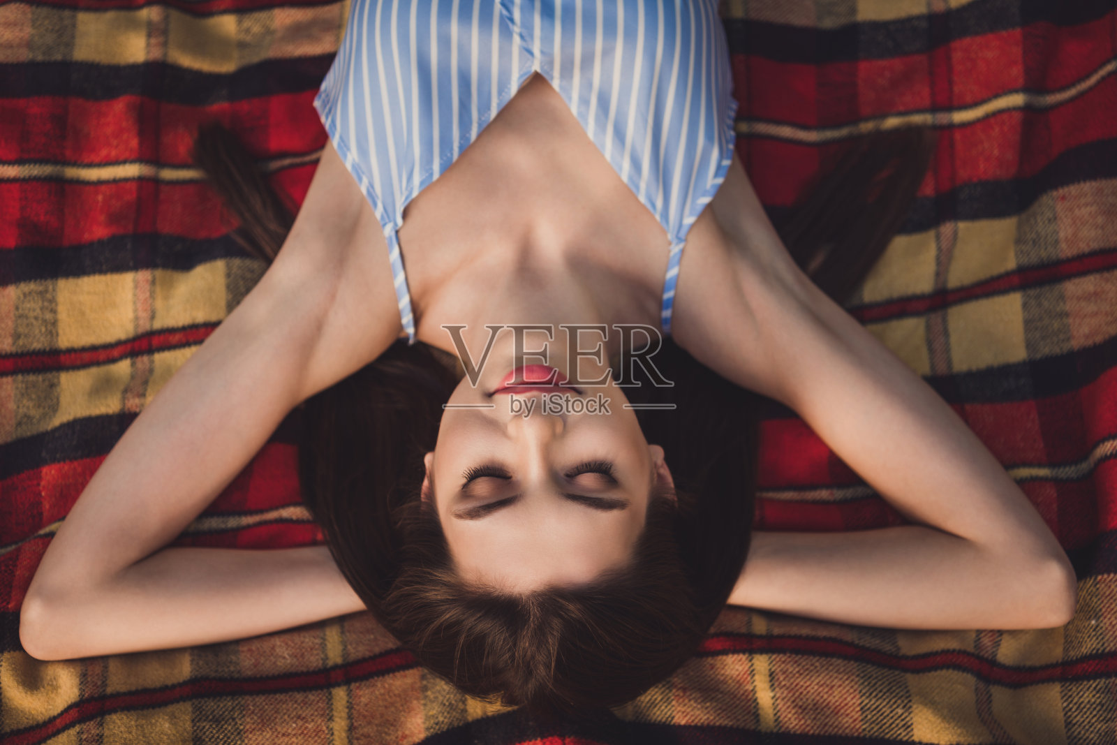 高角度俯视美丽梦幻的女孩,安静地躺在毯子上,呼吸新鲜空气,享受户外的闲暇时光。照片摄影图片