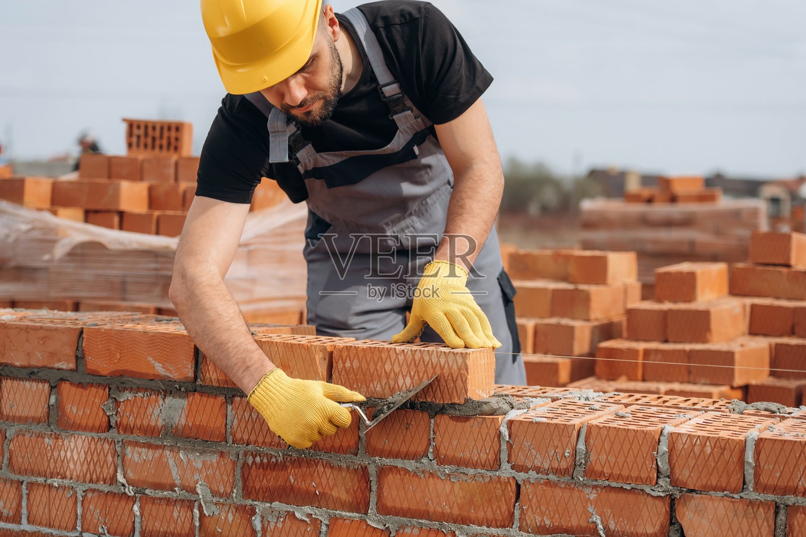 忙于砖块工作的建筑工人在户外工作照片摄影图片