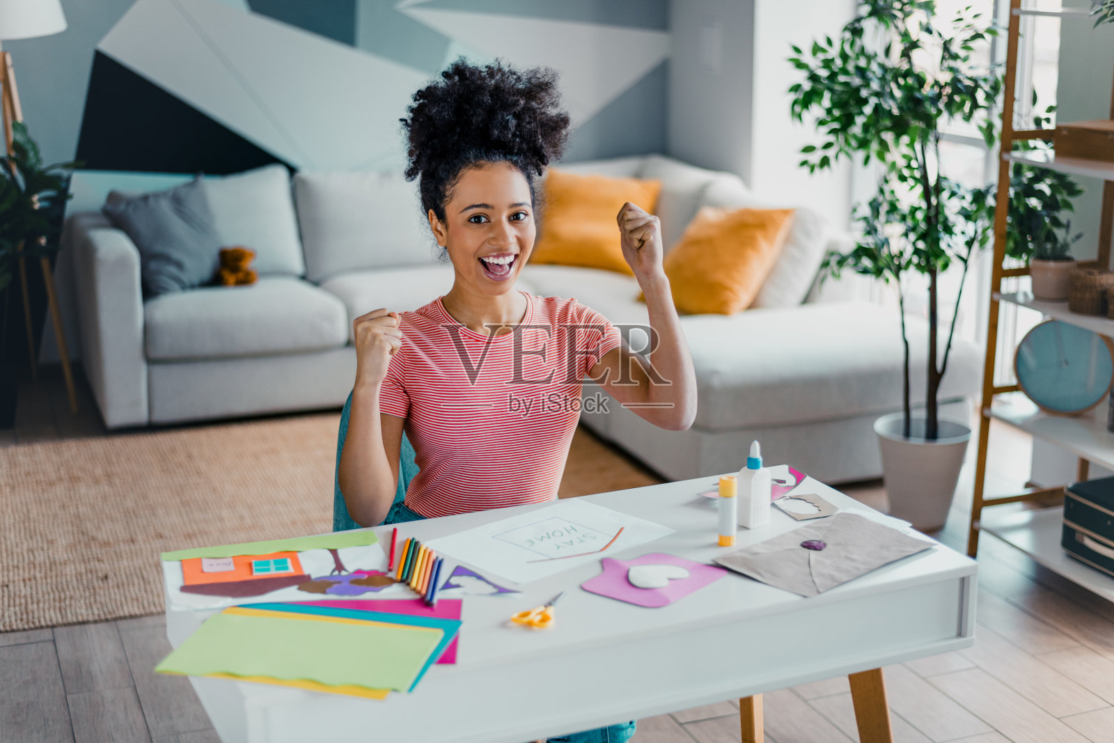 快乐的女性在家中创作手工艺品,享受闲暇时光,表达着在舒适时尚的现代公寓内的幸福感。照片摄影图片