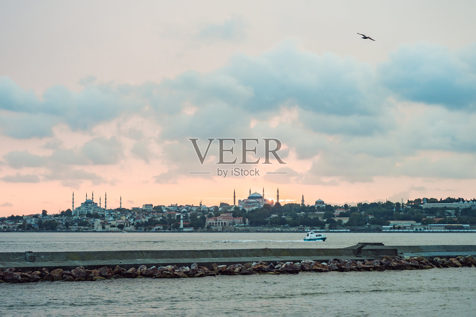 土耳其伊斯坦布尔的日落。旅游船在夏季的金角湾航行。伊斯坦布尔海滨美丽的阳光景色,背景是古老的清真寺。旅行、旅游和度假的概念,聚焦于伊斯坦布尔和土耳其。照片摄影图片