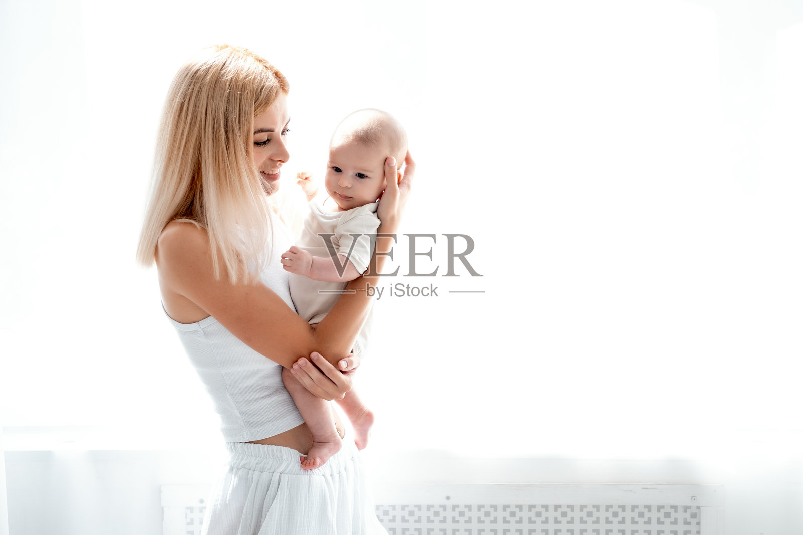 年轻母亲轻柔地拥抱着新生女婴,母女之间充满了母爱与关怀,年轻家庭,母女情深,留白处可添加文字照片摄影图片