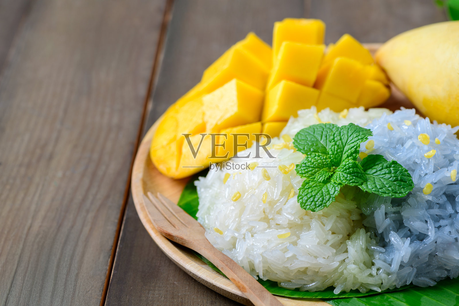 熟透的芒果糯米饭是一道经典的泰国甜点,将熟透芒果的天然甜味与浓郁、奶油味的椰子糯米饭相结合。照片摄影图片