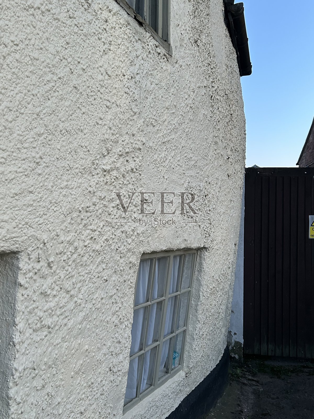 白色渲染建筑,墙壁大幅弯曲,倾斜的墙壁照片摄影图片