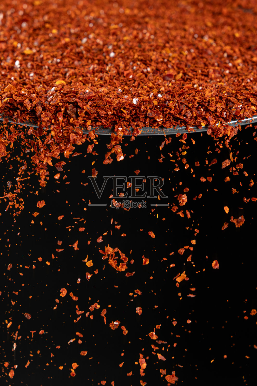压碎的红辣椒粉,宏观辣味调料,倒在黑色背景上照片摄影图片
