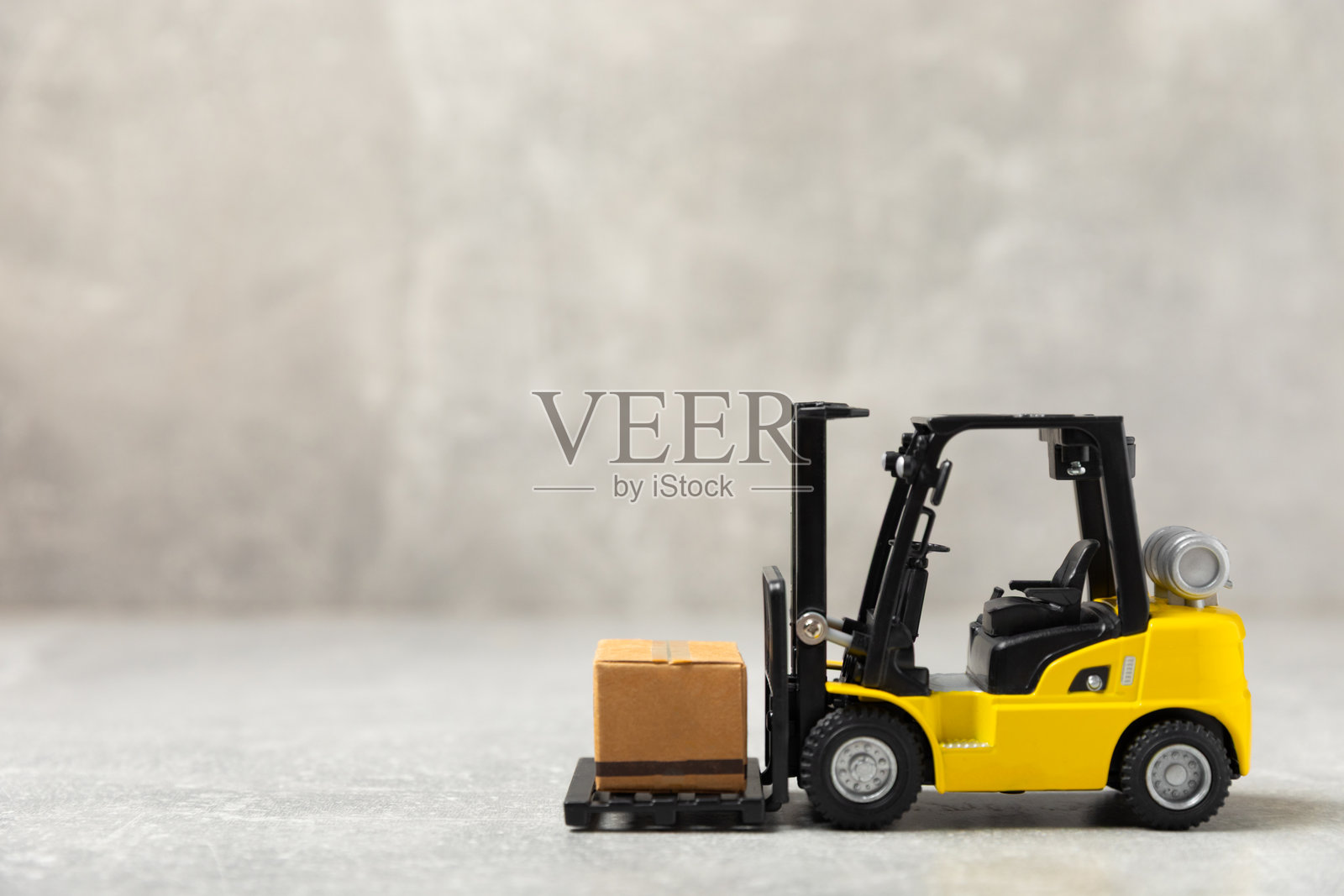 黄色叉车和黄色卡车在明亮的背景下。物流概念。在线购物的物流和供应链管理。商品或产品的全球配送。纸箱。照片摄影图片