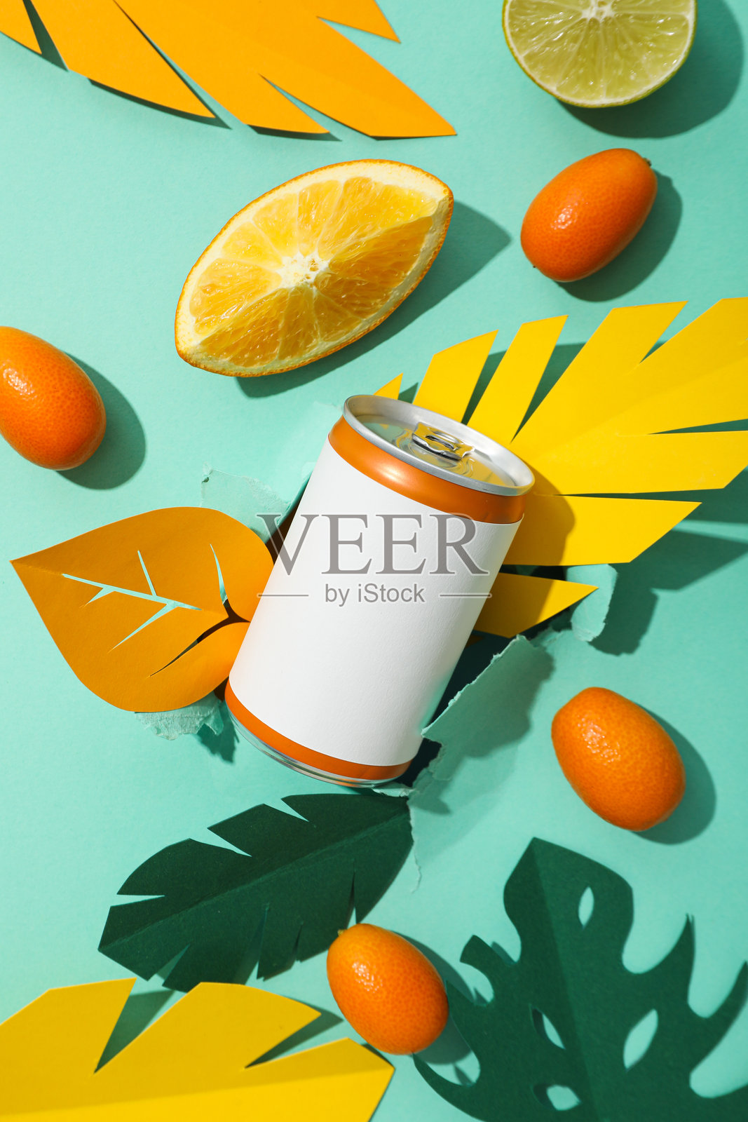 绿色背景上的铁罐、柑橘类水果和纸叶,俯视图照片摄影图片