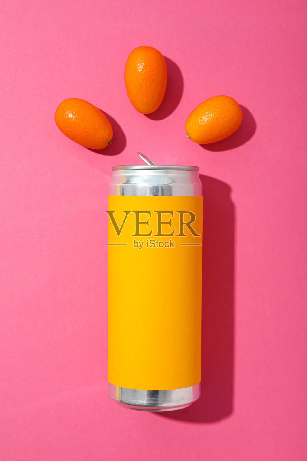 粉色背景上的铁罐和金橘,俯视图照片摄影图片