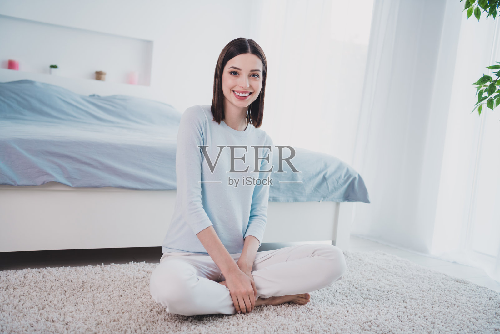 迷人快乐的女孩坐在地板上休息,享受美好的清晨,待在室内。照片摄影图片