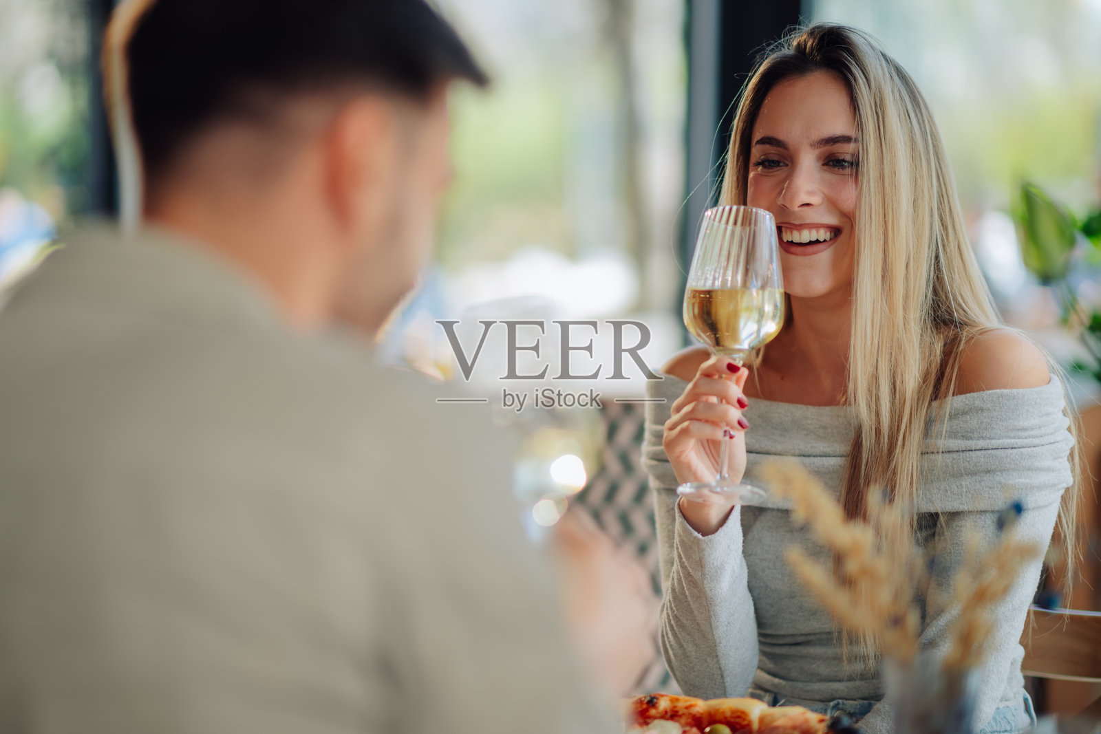 年轻情侣在户外餐厅享受葡萄酒和比萨饼照片摄影图片