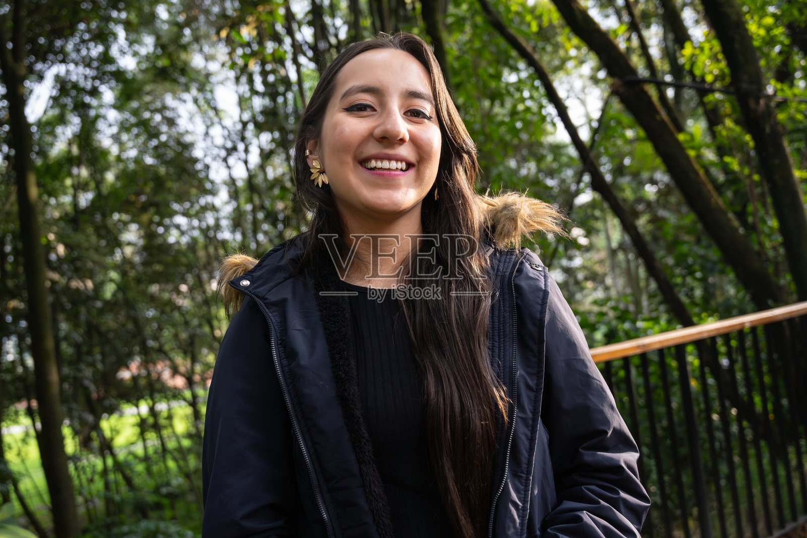 年轻女性在森林中呼吸新鲜空气。微笑的女性徒步旅行者肖像照片摄影图片