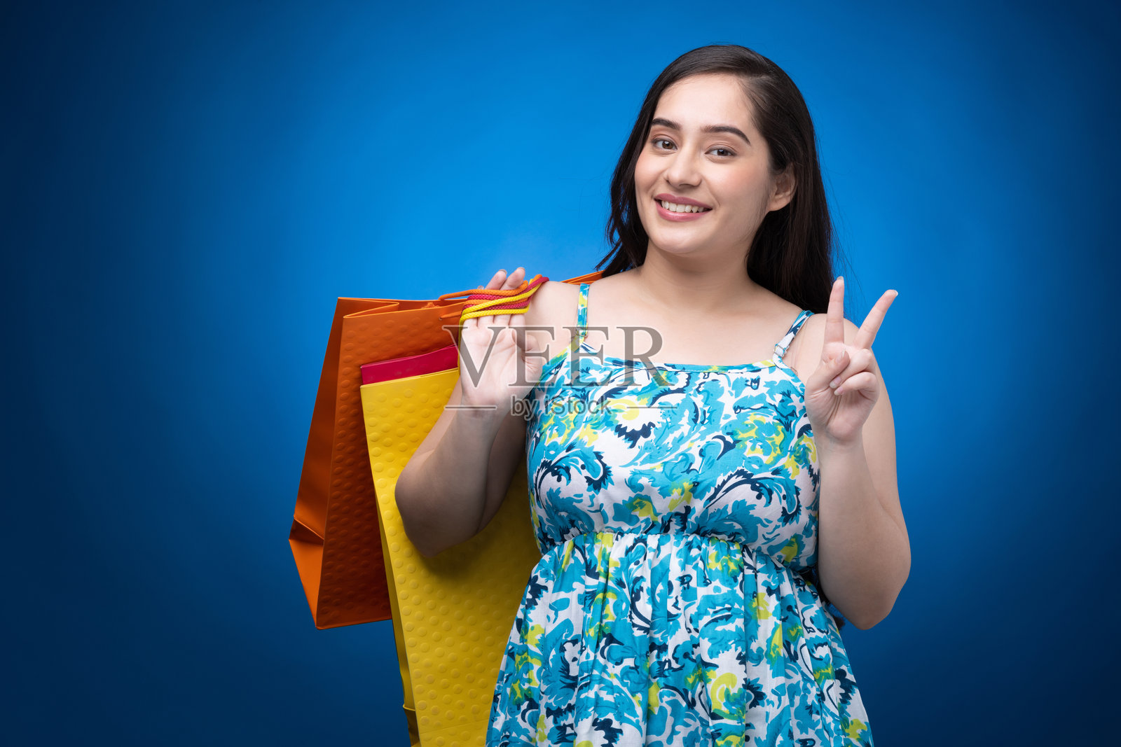 年轻女性穿着裙子的肖像,背景为蓝色照片摄影图片