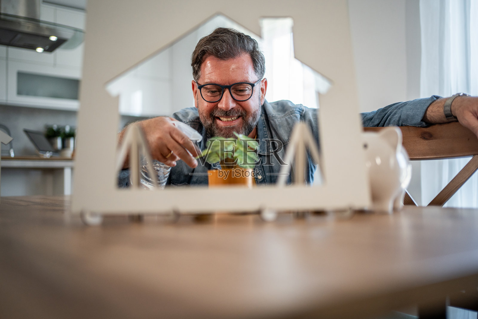 男人给植物浇水,象征着新家投资的增长照片摄影图片