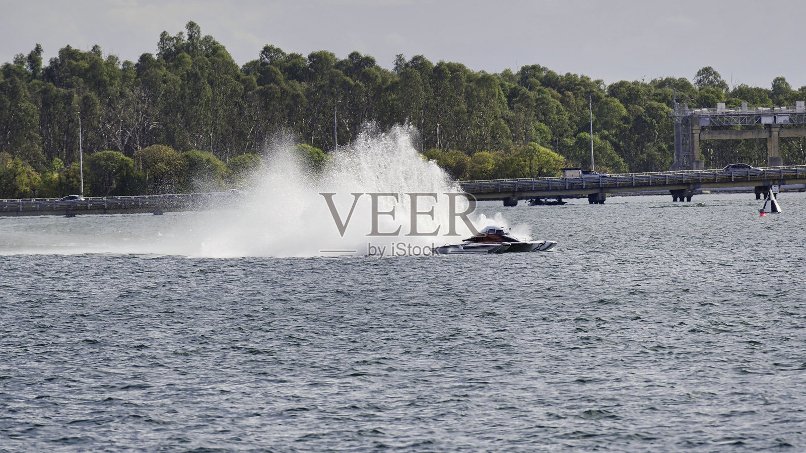 快艇在雅拉旺加水坝桥附近进行爆炸性测试时激起浪花照片摄影图片