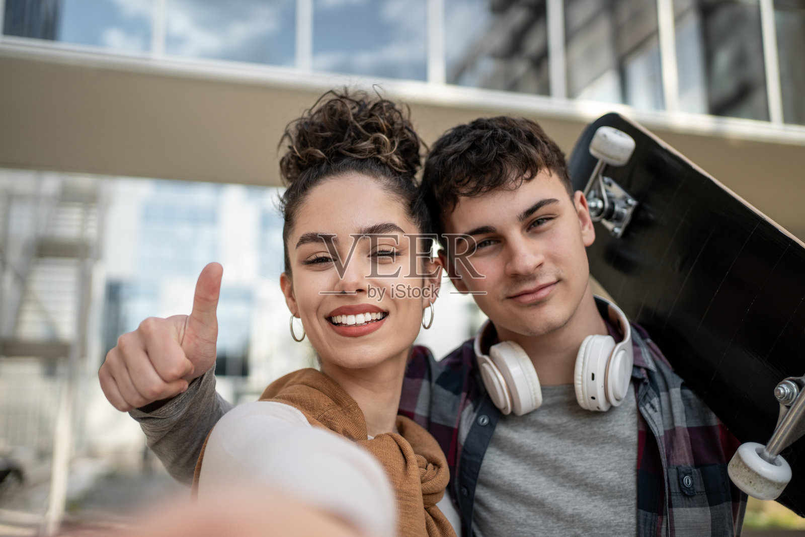 青少年们在滑板上竖起大拇指自拍照片摄影图片