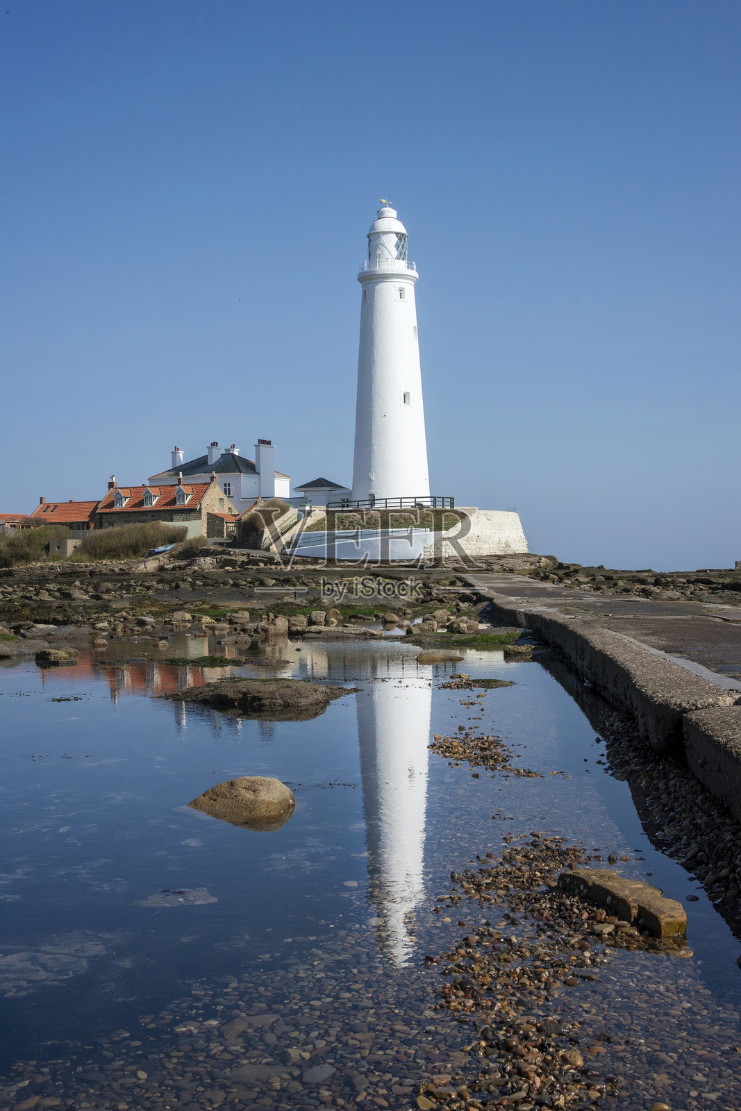 中央的白色灯塔,旁边有一条通往它的单一路径照片摄影图片