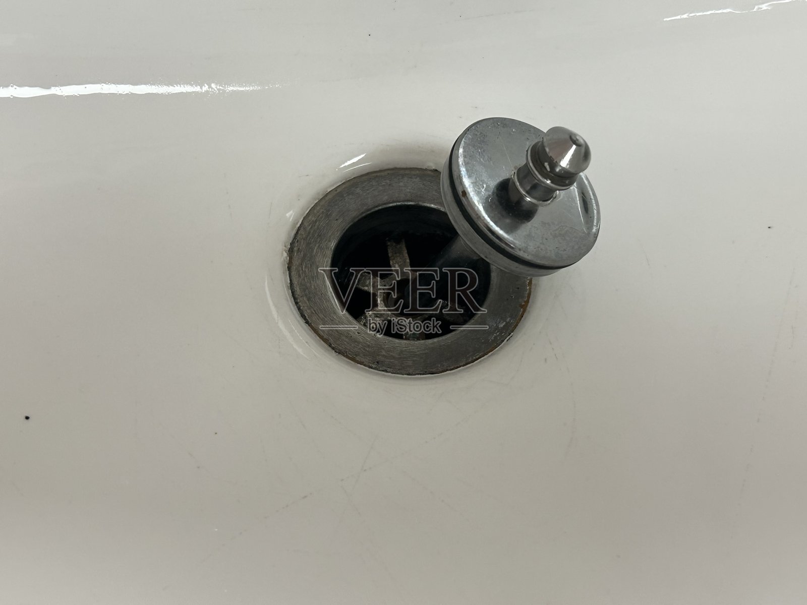 白色陶瓷水槽,带不可拆卸的水塞,特写照片照片摄影图片