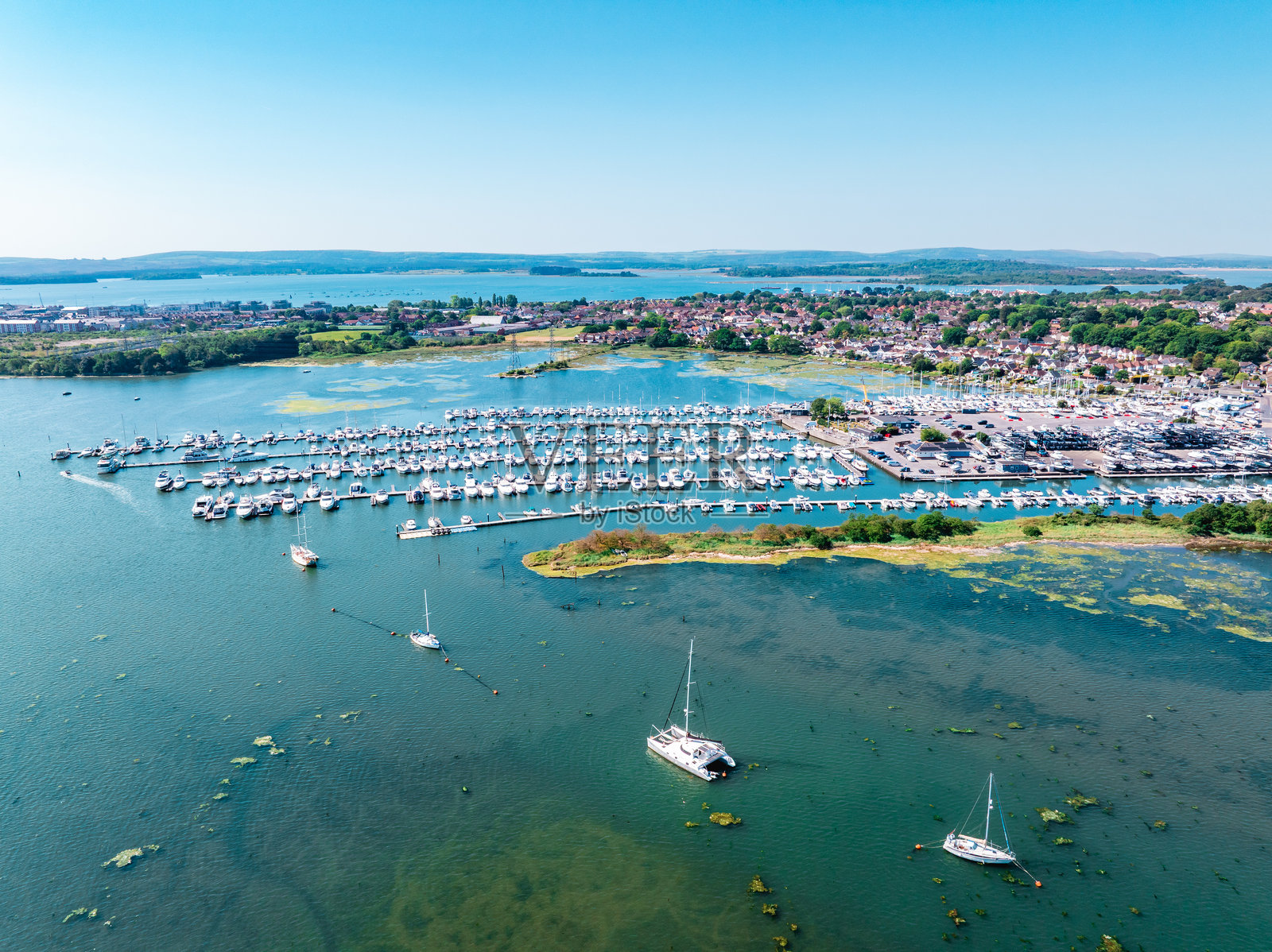 在英格兰多塞特的普尔港,阳光明媚的日子里停靠着船只。照片摄影图片