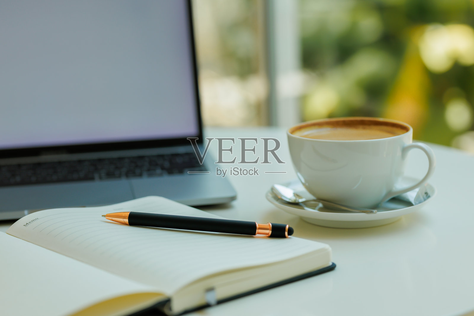 整洁的桌面俯视图,配有笔记本、钢笔、咖啡和笔记本电脑,适合表现生产力、专注和远程工作的主题。照片摄影图片